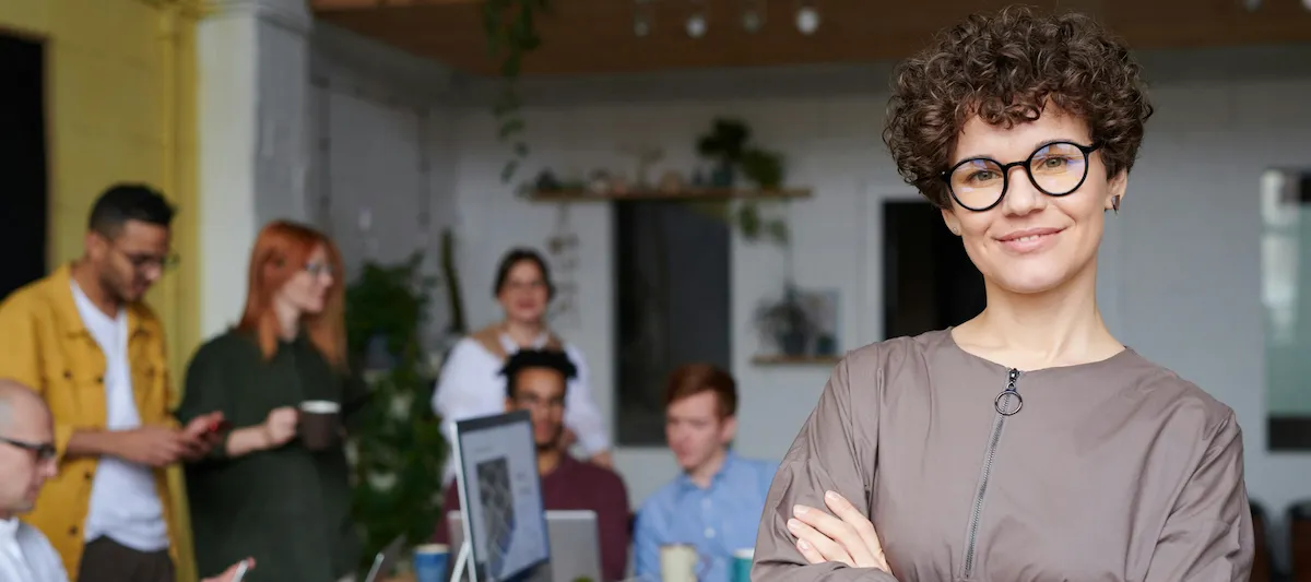 Freundliche Frau mit KollegInnen im Hintergrund